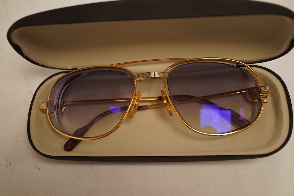 Two pairs of vintage Cartier gilt metal glasses, a pair of Gucci glasses and another